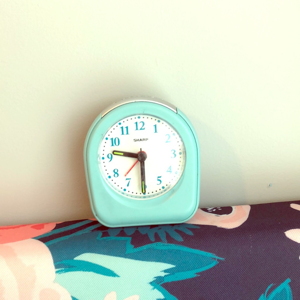 Light blue analog alarm clock.